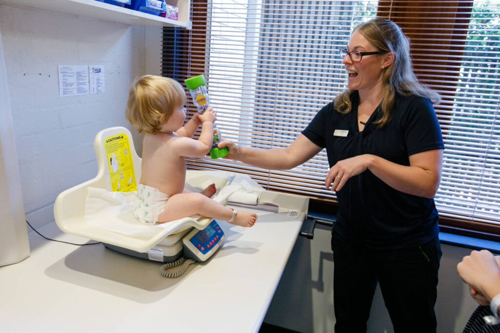 A toddler with a nurse at a health clinic in Canberra